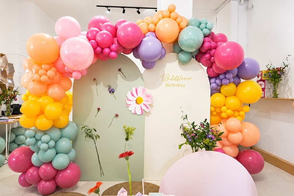 Composición orgánica completa de globos en tonos rosa, pastel y naranja para cumpleaños infantil